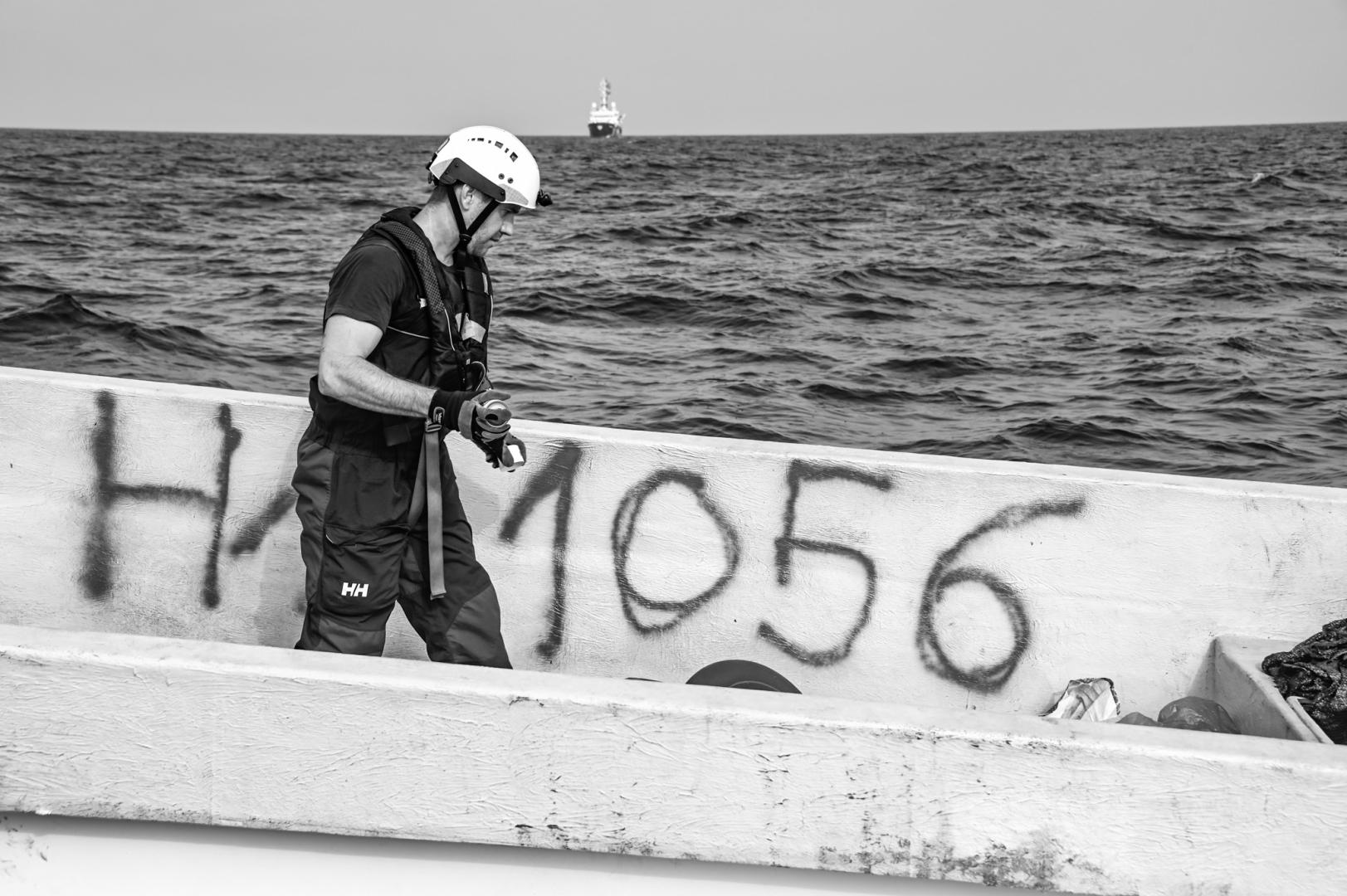 After rescued people are embarked, crew member Jo marks the empty boat so it is clear a SAR operation has taken place.