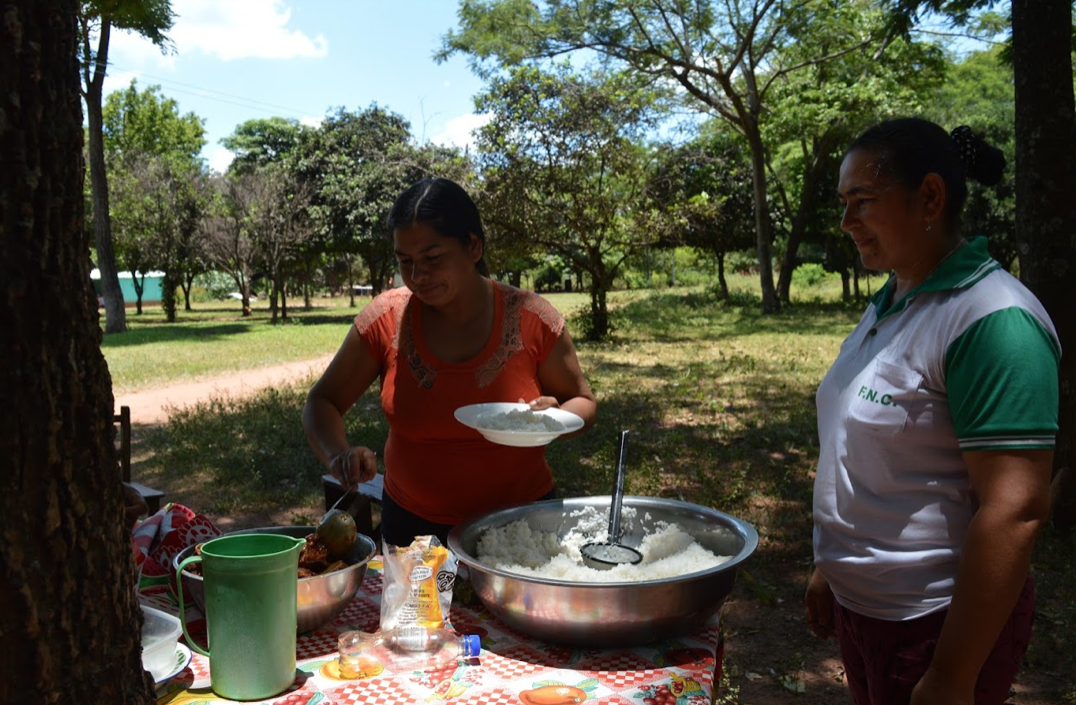 FNC general secretary Teodolina Villalba and a compañera serving food to a community event in Sebastián Larrosa, another FNC settlement. Photo by Inés Franceschelli