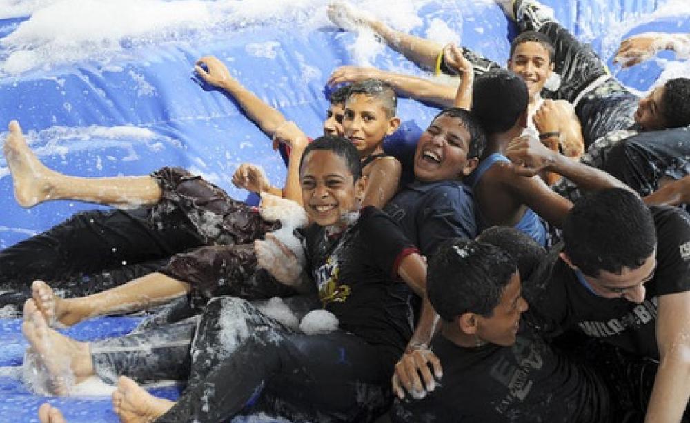 Happy days: children of Gaza play on a water slide during UNRWA Summer Fun Weeks, 2013. Photo: United Nations Photo via Flickr.