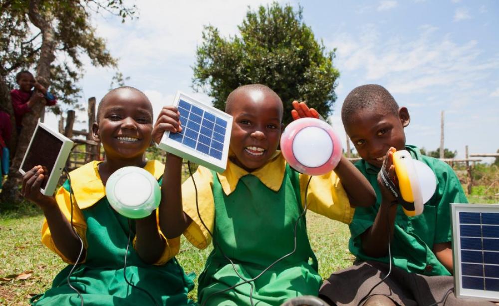 School children from Kembu primary school holding solar lights, Longisa, Bomet county, Kenya. Photo: Corrie Wingate Photography / SolarAid via Flickr (CC BY).