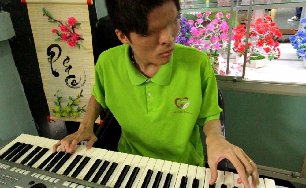 A keyboard player, blind from birth due to a genetic defect induced by Agent Orange, performing at the War Remnants Museum. Photo: Mick Grant.