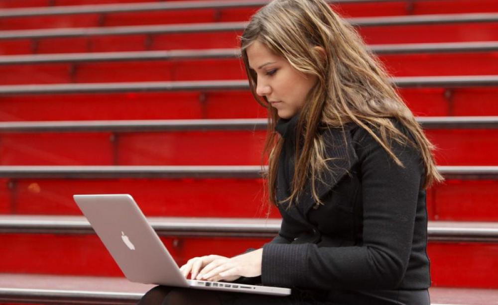 Meg Montgoris using free Wi-Fi on the red stairs on Duffy Square. Photo: Adam Pantozzi / Times Alliance / Yahoo via Flickr (CC BY).