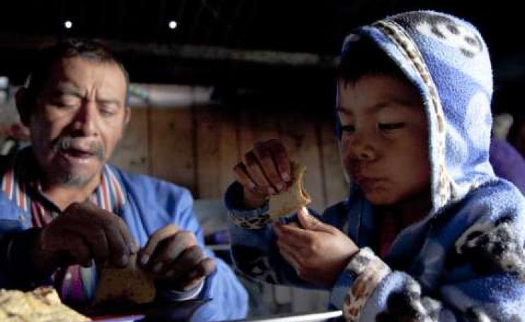 A former undocumented worker in the USA, Marvin Garcia Salas shares food with his son, Jesus, at home in Chiapas, Mexico. Photo: Bread for the World via Flickr.